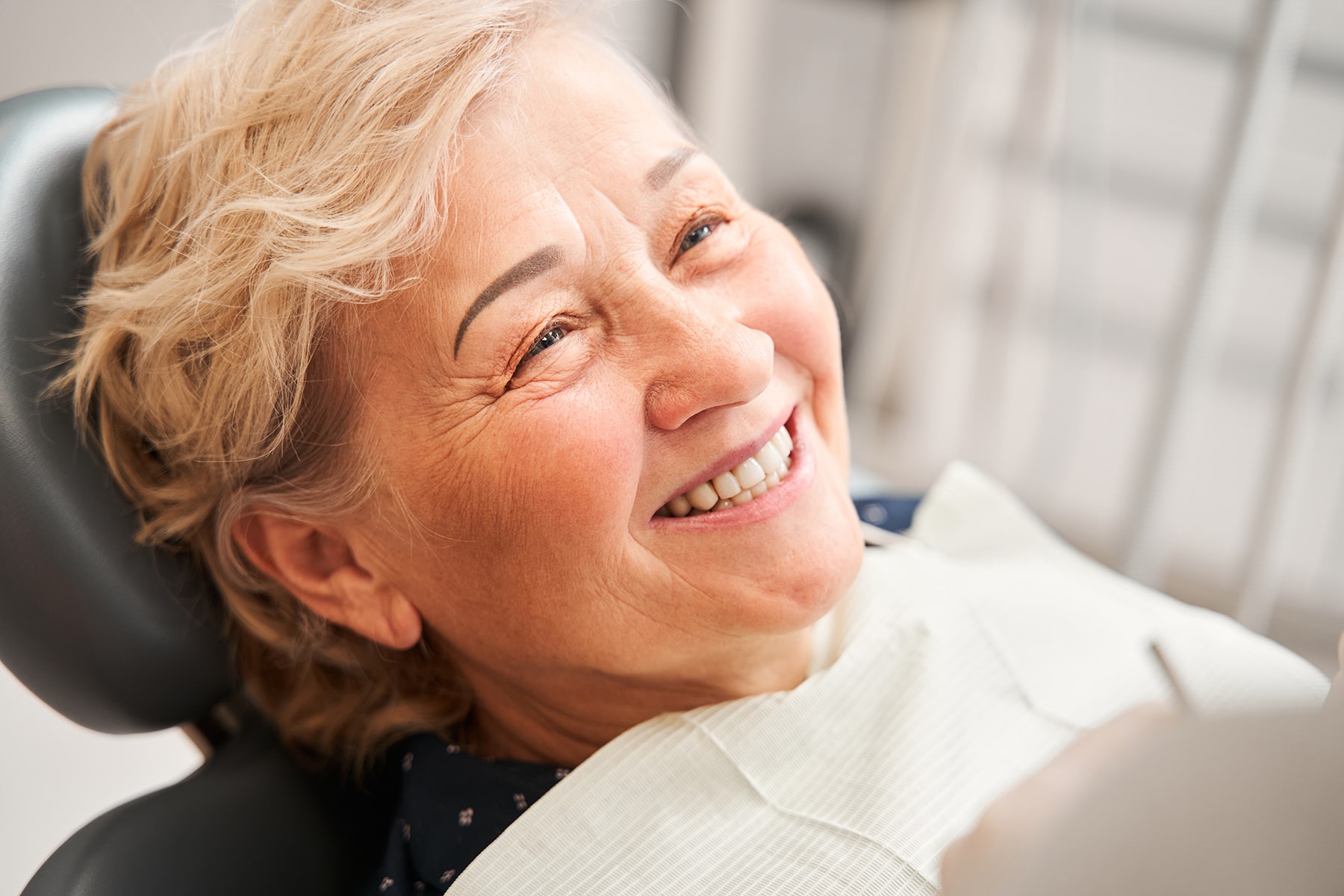 Woman smiling with denture replacements in Apex, NC